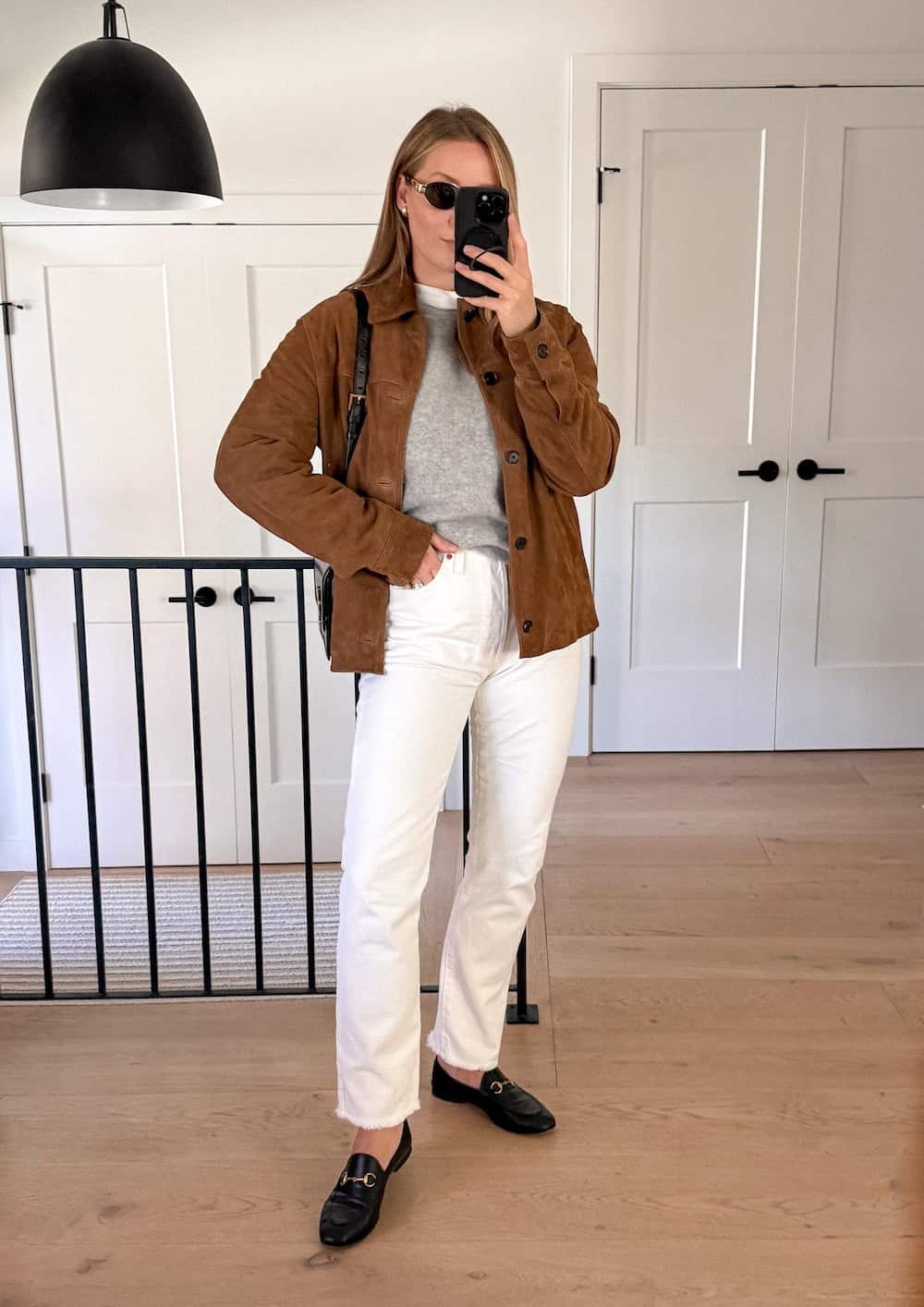 Christal wearing white jeans with a suede coat and loafers.