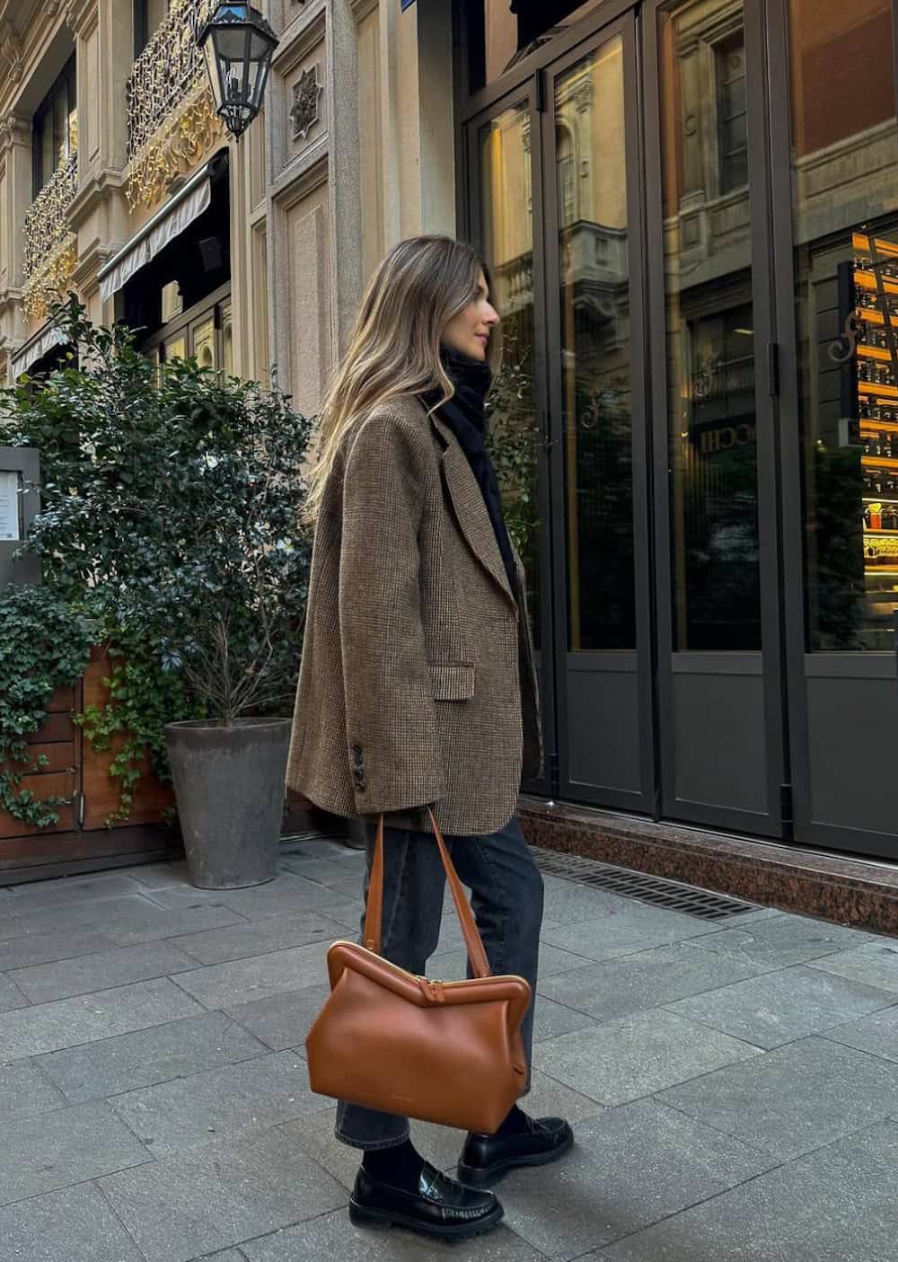 Woman wearing jeans, loafers and a boxy blazer.